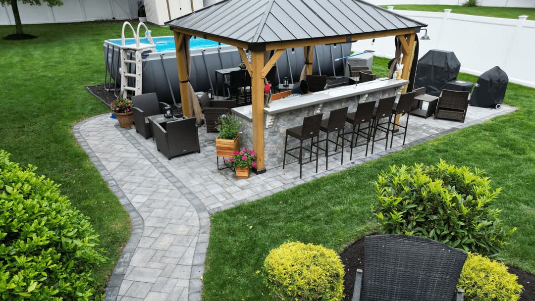 Backyard oasis with a gazebo, bar seating, pool, and landscaped pathways. Perfect for entertaining.