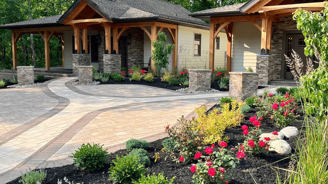Beautifully landscaped entrance with stone pathways and vibrant flower beds in a serene setting.