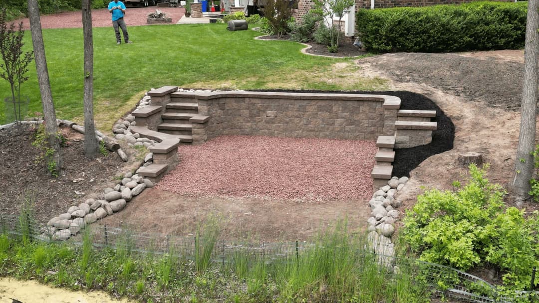 Landscaped stone patio with steps and garden beds, ready for outdoor relaxation and enjoyment.