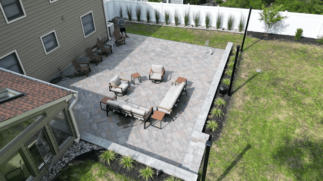 Aerial view of a backyard patio with seating area and landscaped yard.