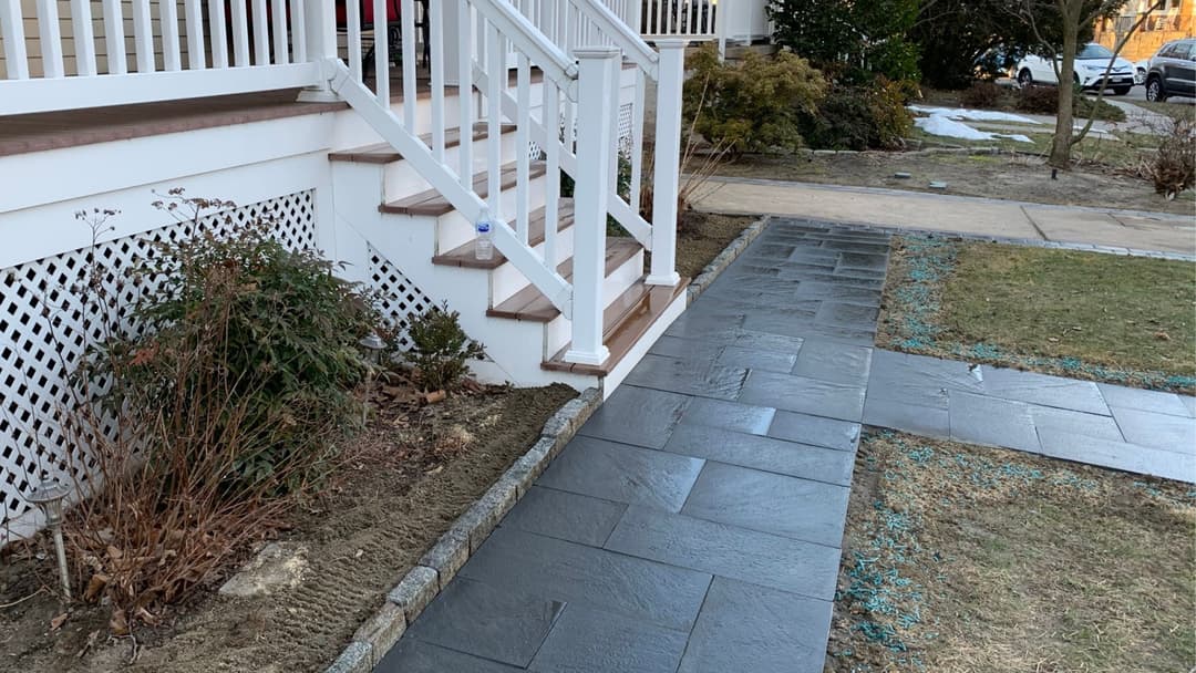 Front steps of a house leading to slate walkway and garden, showcasing landscaping details.